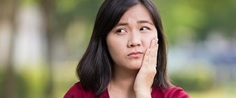 Woman in pain holding cheek